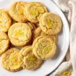 Golden lemon sugar cookies with crisp edges and soft crumb on rustic board.