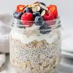 Morning overnight oats in a jar with fresh berries, chia seeds, yogurt, and honey.