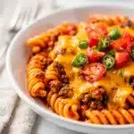 One pot beef taco pasta with seasoned beef, rotini, and melted cheese.