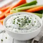 Creamy homemade ranch dip dressing with fresh dill in a rustic bowl.