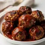 Slow cooker BBQ meatballs in glossy sauce with fresh parsley garnish