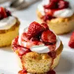 Close up of homemade strawberry shortcake cups with juicy berries and whipped cream