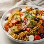 Colorful summer Italian pasta salad with creamy mozzarella and fresh vegetables.