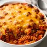 Hearty ground beef casserole with pasta, tomato sauce, and melted cheddar cheese.