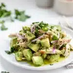 Creamy avocado chicken salad with cilantro and lime in a white bowl.