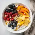 Vibrant cottage cheese fruit bowl topped with fresh berries and golden honey.