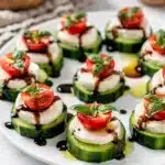 Cucumber Caprese Bites on a rustic board with mozzarella and tomatoes