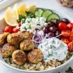 Greek chicken meatball bowls with tzatziki quinoa and fresh vegetables plated beautifully.