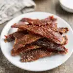 Make ahead homemade beef jerky recipe on rustic wooden cutting board