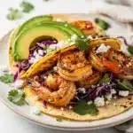 Honey lime shrimp tacos close up on rustic board