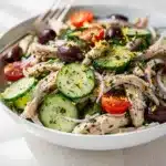 Lemon herb chicken salad with creamy dressing on crisp fresh ingredients
