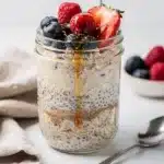Creamy overnight protein oats in a jar topped with fresh berries and chia seeds.