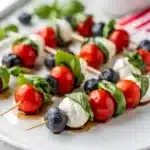 Patriotic Caprese Skewers with tomatoes mozzarella and blueberries on wooden board