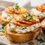 Creamy goat cheese and juicy peaches top crispy toasted baguette crostini.