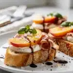 Peach prosciutto bruschetta with creamy mozzarella on toasted baguette slices