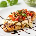 Pesto bruschetta chicken with melted mozzarella and balsamic glaze.