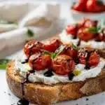 Roasted tomato goat cheese toast on rustic bread with balsamic glaze and basil