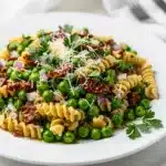 Vibrant rotini pasta salad with peas and sun-dried tomatoes.