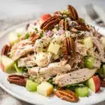 Rotisserie chicken salad with celery, apple, and pecans in a bowl.