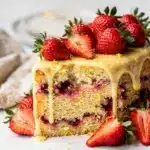 Close-up strawberry lemon cake slice on rustic wooden table.