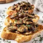 Creamy truffle mushroom bruschetta on toasted baguette with thyme and Parmesan