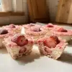 Homemade frozen strawberry cheesecake bites on white countertop